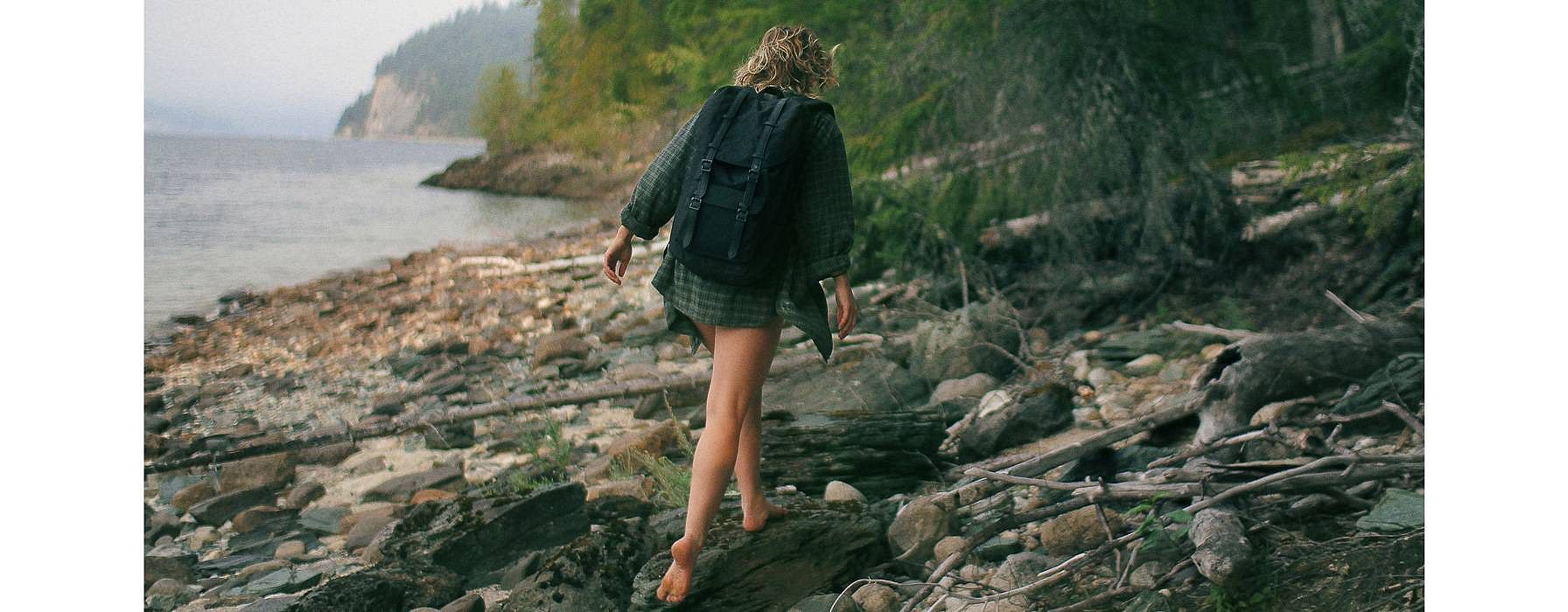 woman walking in the woods near water
