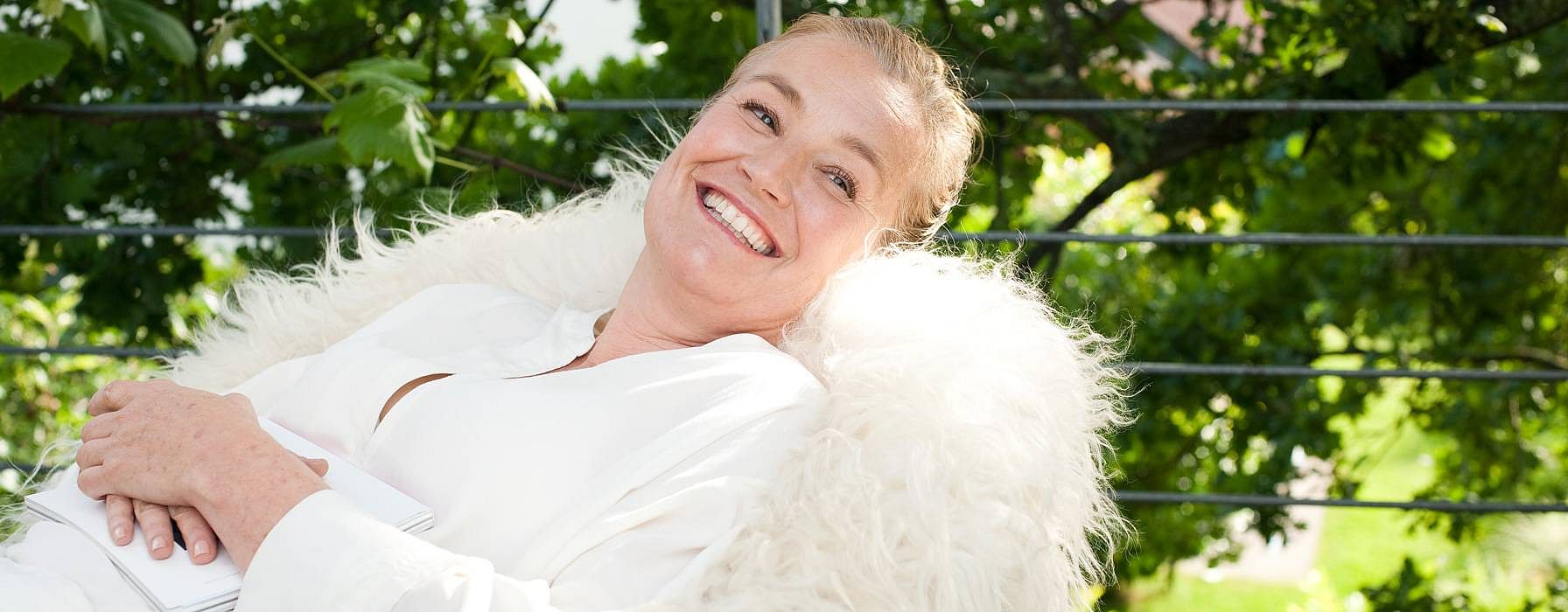 woman lying on a white fluffy chair