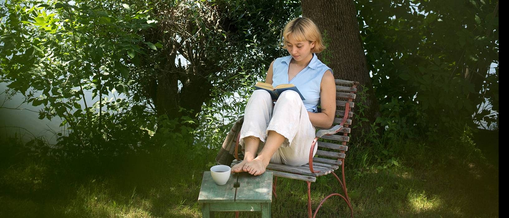 women reading book near water