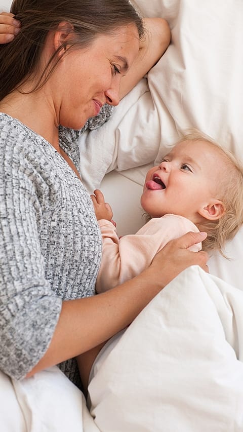 Mother and baby cuddeling in bed