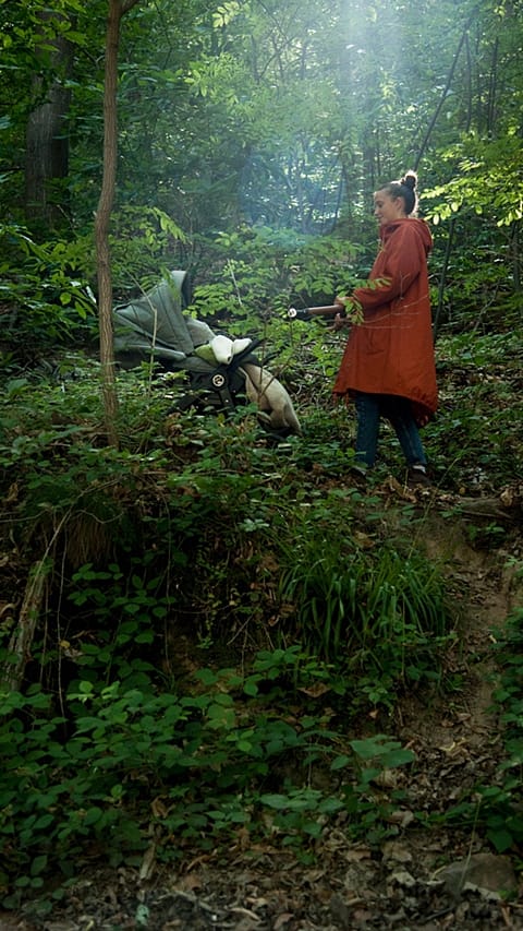 Mother with stroller walking in the woods