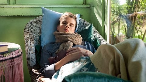 Sick woman with a warm bottle taking a nap
