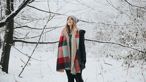 woman standing in woods in winter