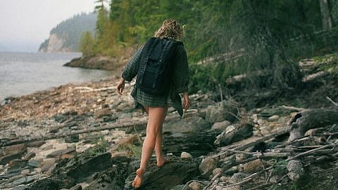 woman walking in the woods near water