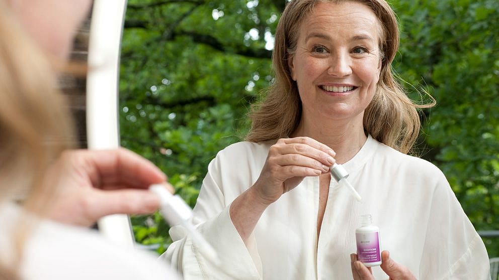 Woman applying drops of Evening Primrose Age Revitalising Concentrate