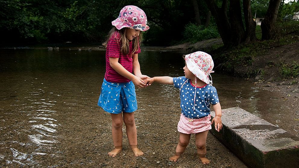 2 children playin by the water